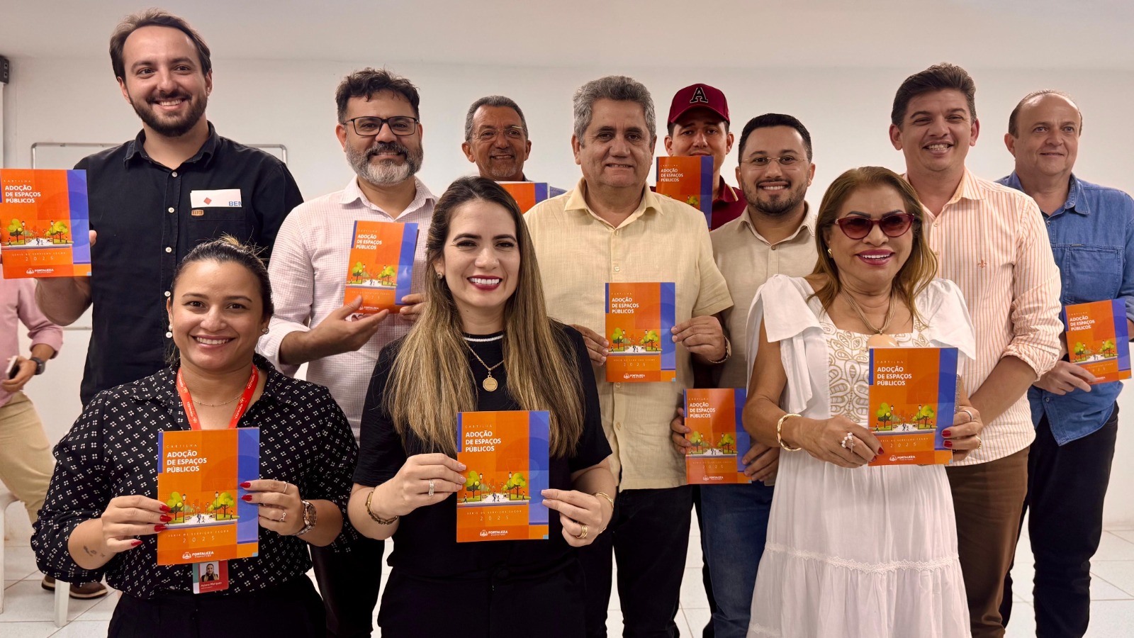 grupo de pessoas posa para a foto segurando a cartilha